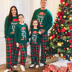 Family of four wearing matching Christmas pajamas in front of a decorated Christmas tree.