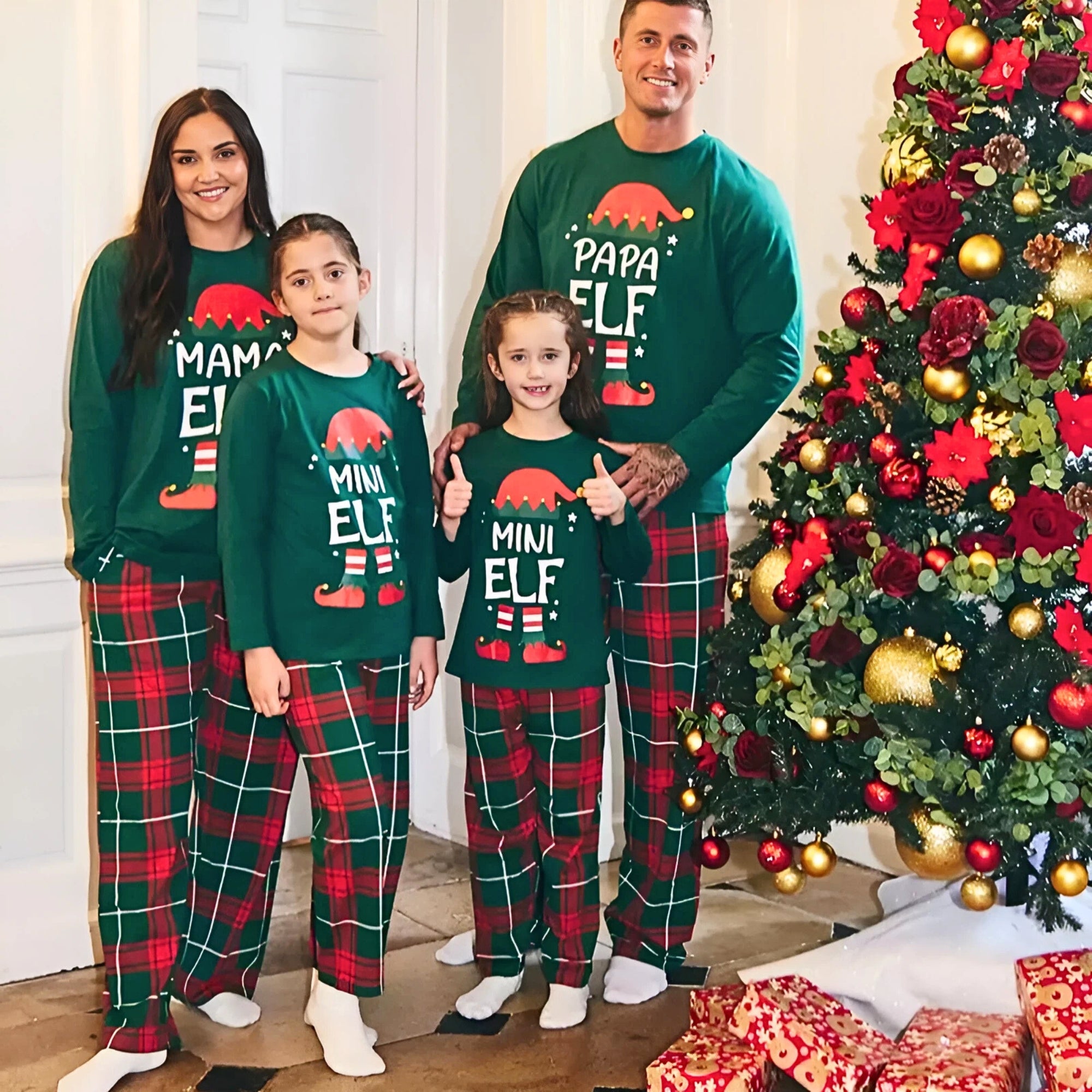 Family of four wearing matching Christmas pajamas in front of a decorated Christmas tree.