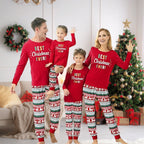Family of four wearing matching red Christmas pajamas with 'Best Christmas Ever!' text, standing in a living room with a decorated Christmas tree.
